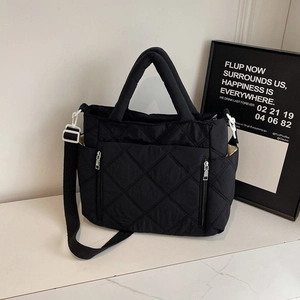 Chic black quilted crossbody bag with dual handles and stylish zipper pocket design