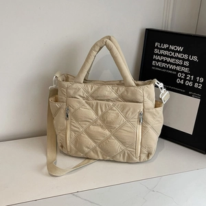 Beige quilted puffer tote bag with adjustable shoulder strap and multiple front pockets