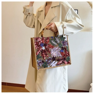 Close-up of bamboo handle tote with colorful floral sequin embroidery on linen