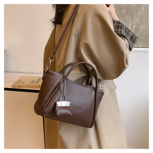 Brown litchi leather shoulder bag with white contrast stitching and a mini pouch charm
