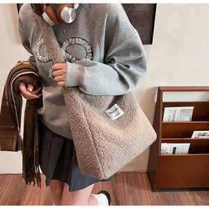 Close-up of the plush brown faux fur texture and white Muheti woven label on the tote bag