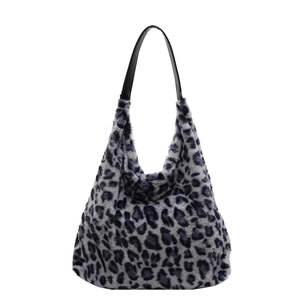 Grande borsa tote leopardata in peluche con spalline in pelle nera su sfondo bianco