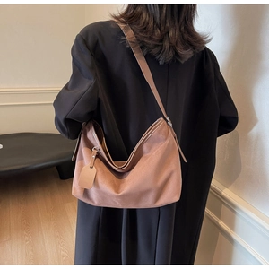 Détail d'un grand sac bandoulière marron en similicuir avec décorations minimalistes