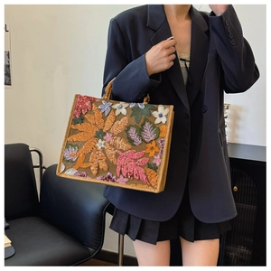 Detailed close-up of colorful floral embroidery and sequins on the linen tote bag
