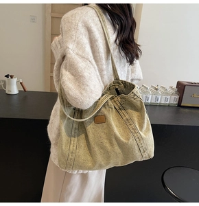 Close-up of vintage washed canvas tote bag in olive green with leather logo patch detail