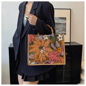 Close-up of sequin floral embroidery on linen tote bag with bamboo handles