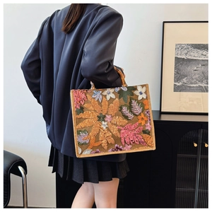 Detail of floral embroidery and sequins on tote bag with bamboo handle