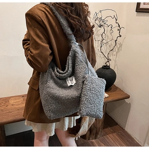 Detail of grey fuzzy fleece tote bag and matching pouch on a model in vintage suit