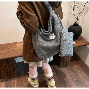 Detail of plush grey teddy fur tote bag with matching zipper pouch and letter label