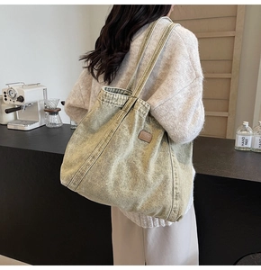 Detail of vintage washed canvas tote bag with brown leather tag in cozy cafe setting