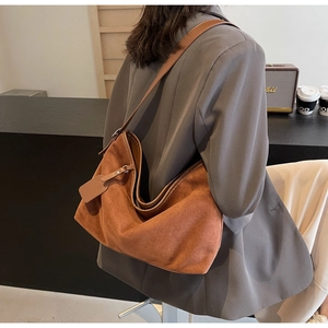 Détail macro du grand sac cabas en daim marron avec bandoulière et intérieur très spacieux