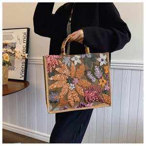 Close-up of tropical flower sequin embroidery and natural bamboo handle on linen tote bag
