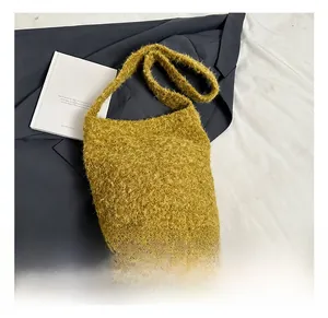 Vue détaillée de la texture en fausse fourrure jaune et de la large bandoulière du sac seau