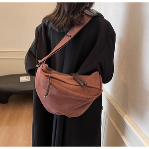 Detail of vintage brown half-moon crossbody bag with braided zipper and wide shoulder strap
