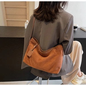 Détail macro du sac cabas en daim caramel avec sangles réglables et texture lisse