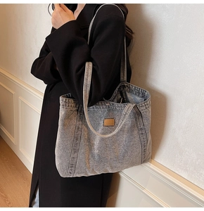 Lifestyle shot of large washed canvas tote bag worn on shoulder by a female model
