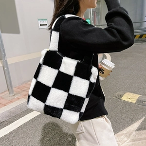 Close-up of black and white checkered plush tote bag with soft faux fur texture