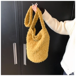 Détail d'un sac seau jaune gingembre en fausse fourrure avec texture pelucheuse