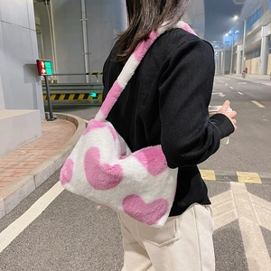 Vue détaillée du sac bandoulière en peluche avec motifs de cœurs roses sur fond blanc