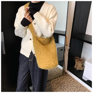 Vue détaillée d'un sac bandoulière en fausse fourrure jaune-vert avec bandoulière large