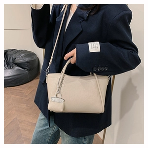 Close-up of cream white lychee texture handbag with a mini coin purse and long shoulder strap