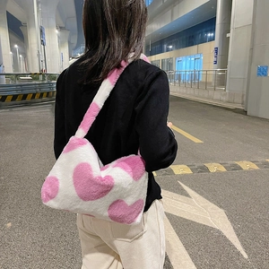 Détail de la texture en peluche douce et des motifs de cœur rose du sac à bandoulière