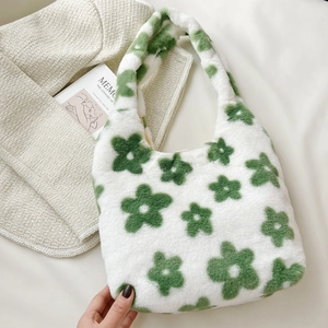 Dettaglio della borsa in peluche bianca con motivo floreale verde in un contesto lifestyle