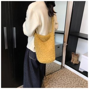 Détail du sac seau jaune en polaire montrant la texture douce et la large bandoulière