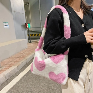 Gros plan du sac porté épaule en peluche blanche avec grands cœurs roses et texture douce