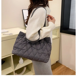 Detail of grey quilted nylon tote bag showing diamond stitch and puffy texture