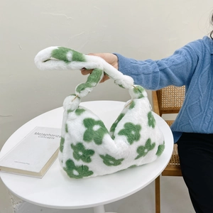 Floral plush shoulder bag with green flowers and gold metal rings shown on a model