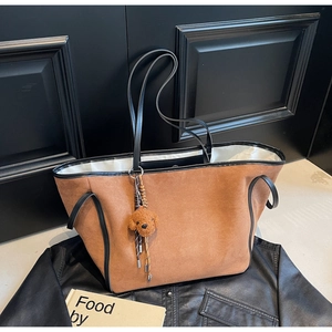Chic brown suede tote bag with black leather handles and cute teddy plush charm detail