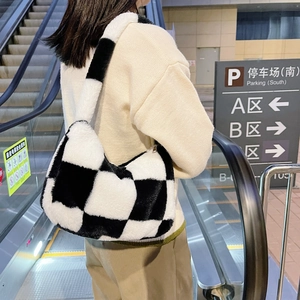 Detail of plush checkered handbag with black and white grid pattern in street style