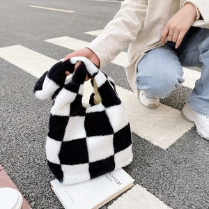 Détail du sac à main en peluche à damier noir et blanc avec texture douce en fourrure