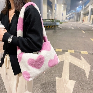 Détail du sac à bandoulière en peluche douce avec motif cœur sur fond blanc
