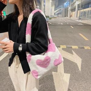 Détail du sac à bandoulière en peluche douce avec motifs de cœurs roses pour l'hiver