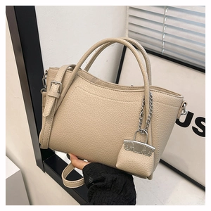 Minimalist beige pebble leather handbag with mini charm and adjustable strap for women