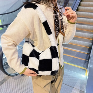 Detailed close-up of fluffy black and white checkered plush shoulder bag texture