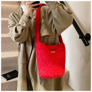Gros plan d'un sac seau en peluche rouge vif avec texture poilue et étiquette logo