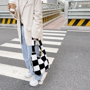 Texture détaillée du sac fourre-tout en peluche à damier noir et blanc en style urbain