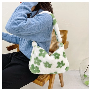 Sac sous le bras en fausse fourrure pelucheuse avec motif floral vert porté par un mannequin