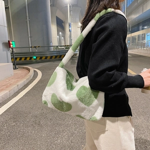 Vue détaillée du sac à bandoulière en peluche à pois blancs et verts sur modèle