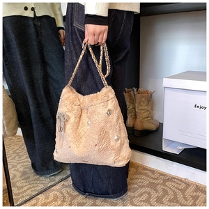 Détail du sac à main en peluche avec nœud en strass et chaîne dorée