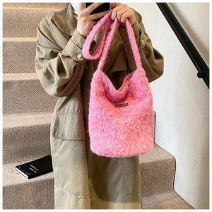 Gros plan détaillé du sac seau rose en fil pelucheux avec étiquette en cuir brun