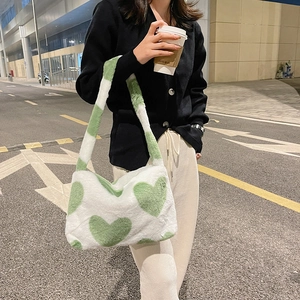 Détail du sac à épaule en peluche douce avec motifs de cœurs verts et large bandoulière