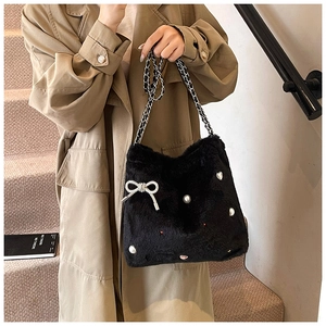 Détail du sac à main en peluche noire avec nœud en strass, perles et bandoulière