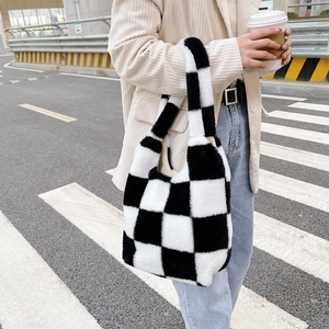 Vue street style d'un sac à bandoulière en peluche à damier noir et blanc pour l'automne