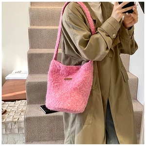 Détail d'un sac seau rose en fausse fourrure pelucheuse sur un trench-coat kaki
