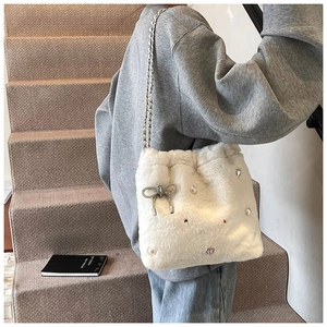 Détail du sac à bandoulière en peluche blanche avec nœud argenté et perles brillantes