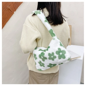 Gros plan du sac hobo en peluche avec motif floral vert sur fausse fourrure blanche